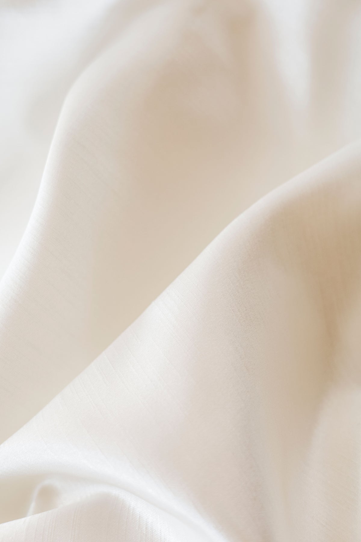 Material textil ivoire cu pliuri delicate, evocând finețea și senzația de curat asociate moscului alb.