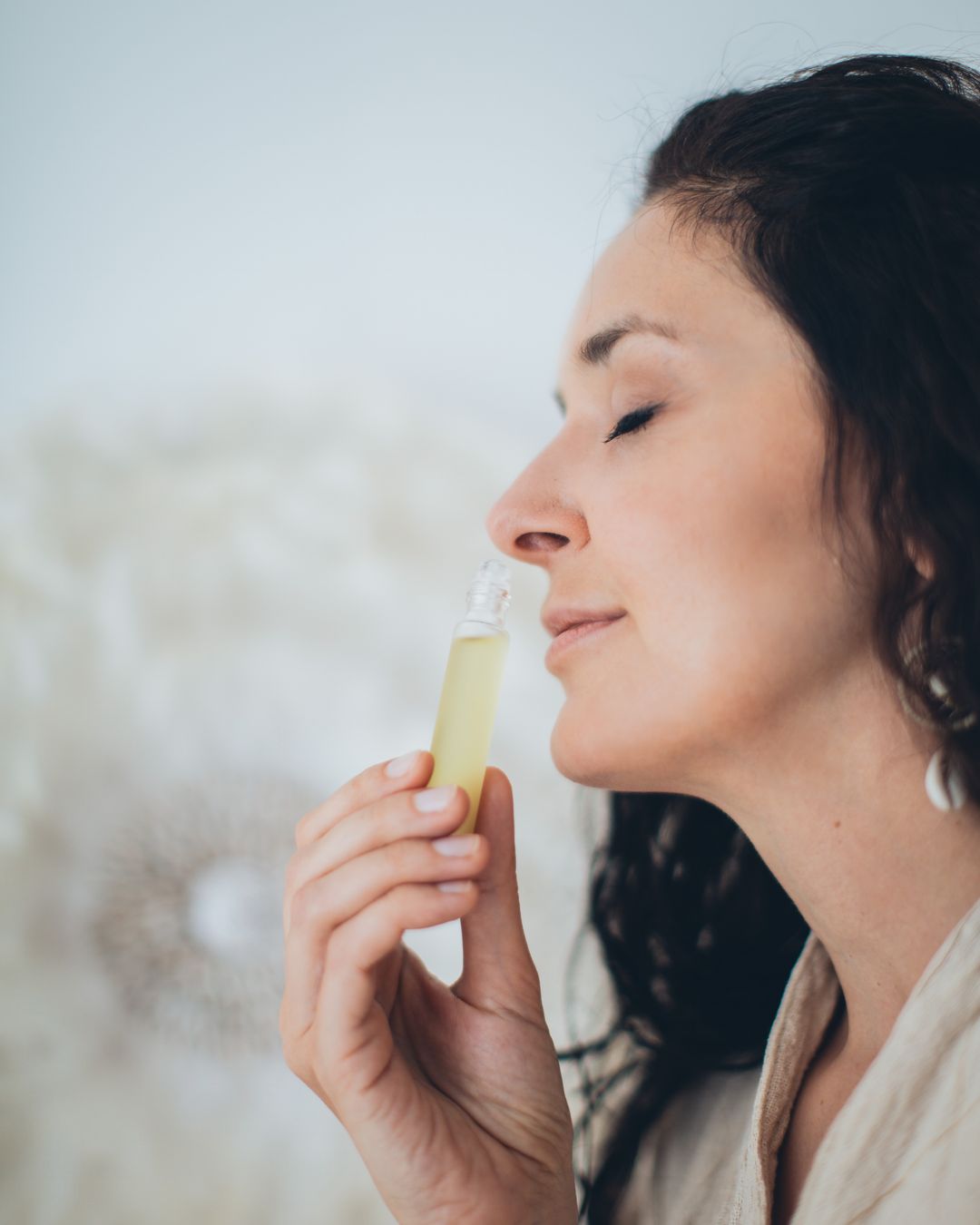 Femeie care miroase un parfum cu ochii inchisi - Little Paris Atelier
